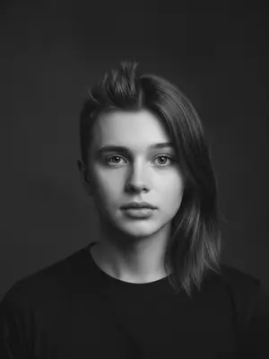 Создайте уникальный портрет, объединив две половины лиц в одно изображение. Выберите одно или два фото для загрузки: мужчины и женщины. При необходимости, внесите коррективы во внешность. Результатом будет интригующий портрет в черно-белой гамме, на котором сочетаются черты обоих лиц. Фотография выполнена в студийной обстановке с акцентом на натуральность, прямой взгляд и мягкое освещение. 