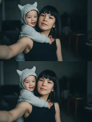 На фотографии, сделанной случайно в стиле жизни, нет никаких знаков постановки. Это реалистичное изображение, зафиксированное на iPhone 17 Pro Max, где отсутствует идеальная симметрия. Кожа выглядит сверкающей, с просвечивающими порами, сохраненная в формате RAW. В интимной обстановке дома модель делает селфи, окруженная мягким рассеянным светом, создающим глубокие, но нежные тени, придающие объем и тепло объятиям. На заднем плане малыш в светло-сером оверсайз худи с объемным капюшоном, украшенным двумя выступающими деталями, напоминающими рожки; он обнимает модель за плечи, его руки нежно, но крепко обхватывают ее. Малыш, улыбаясь, повернут лицом к камере. 