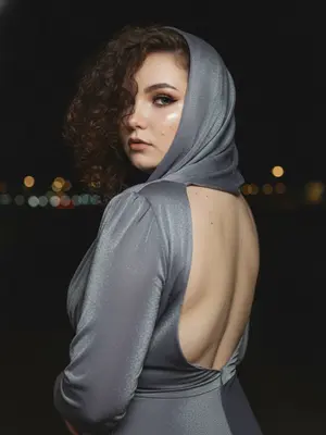 Изысканный гламурный редакционный фотосет. Женщина, изображенная в крупном плане, стоит спиной к камере, но внезапно поворачивается через плечо, словно случайно заметив фотографа. Ее голова нежно поворачивается, создавая естественную динамику без искусственности. Взгляд направлен прямо в объектив - спокойный, холодный и уверенный. 