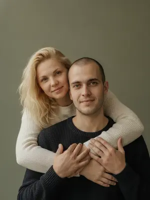 На студийском фотосете запечатлен отец и его дочь, обнимающиеся. Девушка стоит позади мужчины, ее руки ласково обвивают его торс, щека едва касается его головы. Взгляд обоих направлен точно в объектив. В их выражениях - спокойствие, теплота и натуральная нежность, с легкой улыбкой на лицах. 