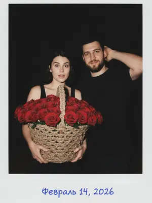 На черном фоне в стиле Polaroid, запечатленный на 35mm пленку в начале 2000-х, вспыхнувший свет. Мужчина и женщина, окруженные тьмой.

Женщина в черном топе, держа огромную корзину из плетеных нитей, наполненную красными розами. В ее глазах удивление, взгляд устремлен на мужчину.

Мужчина в свободной черной футболке, с легкой улыбкой, чешет голову, встречая прямой взгляд объектива.

Они просвечены ярким светом вспышки, камера фиксирует средний план. На белой рамке Polaroid, голубой ручкой, написано: «Февраль 14, 2026».

Аутентичное зерно пленки, высокий контраст, добавляющий нотку ностальгии. 