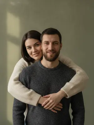 На студийском фотосете запечатлен отец и его дочь, обнимающиеся. Девушка стоит позади мужчины, ее руки ласково обвивают его торс, щека едва касается его головы. Взгляд обоих направлен точно в объектив. В их выражениях - спокойствие, теплота и натуральная нежность, с легкой улыбкой на лицах. 