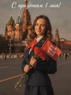 На фоне красной площади в Москве, в золотой час, стоит фигура в советском стиле пионера. Легкая улыбка искренне освещает лицо, глаза светятся радостью, взгляд направлен прямо в объектив. Теплый свет ласкает кожу и волосы, создавая нежные блики. Зернистая пленочная текстура придает изображению кинематографичность, а цветокоррекция в янтарно-красных тонах добавляет теплоты.

Поясной портрет, персонаж стоит вполоборота, держа в одной руке букет красных гвоздик с зелеными листьями, а в другой - маленький красный флажок с зубчатым краем. На флажке выделяется надпись на русском языке: «МИР ТРУД МАЙ», выписанная белым шрифтом.

Детали высоко детализированы: каждая пора на коже, переплетение нитей кружева, отдельные волоски и лепестки гвоздик видны четко. Объектив 85mm f/1.8 захватывает каждую мельчайшую деталь, создавая реалистичный фотопортрет. Фон с размытыми силуэтами Собора Василия Блаженного и красной кирпичной стены Кремля добавляет контекста, сохраняя фокус на модели. 