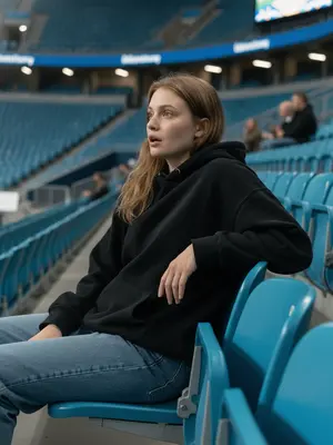 A figure in the stands at a major sports event, captured on a distant live broadcast camera. They are perched in a row of azure seats, reclining slightly, their gaze directed to the side in a moment of astonishment, lips subtly agape. 