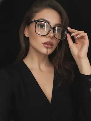 Фотография с винтажным налетом, пропитанная темным шиком в стиле dark glam glasses selfie, создает атмосферу загадочного ночного портрета. Крупный план, кадр обрезает грудь. Модель погружена в процесс селфи, телефон скрыт. Лицо занимает большую часть кадра, слегка повернуто в сторону. Голова наклонена в небольшом углу. Взгляд направлен точно в объектив, выражение спокойное, уверенное и манящее. Губы нежно раскрыты. Рука приподнята к лицу, легко касаясь оправы очков, словно корректируя их положение.

Макияж идеальный в стиле dark glam. Кожа сверкает ровным сияющим оттенком, брови четко выделены темными линиями, ресницы длинные и пышные, стрелка тонкая, контуринг мягкий. Губы окрашены в винно-розовый оттенок с блестящим влажным финишем. 