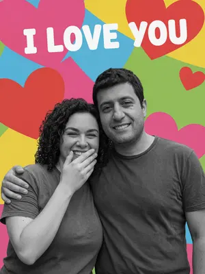 На ярком фоне с надписью "I love you" и красными сердечками расположены два человека. Они смотрят друг на друга, слегка наклонившись вперед, создавая ощущение близости и движения. Тела расслаблены, наполнены живыми эмоциями, их лица искренне светятся от смеха.

Один из них ласково обнимает плечи другого в неожиданном жесте нежности. Другой прикрывает рот рукой, глаза его прищурены от радостного смеха. Их лица сохранены в черно-белом контрасте, подчеркивающем естественную красоту без искажений.

Фон остается ярким и цветным, не закрывая буквы и символы. Коллаж выполнен аккуратно, с реалистичным светом, мягкими тенями и сохранением фотореализма. Люди выглядят черно-белыми на фоне ярких красок, создавая контраст и гармонию в изображении. 